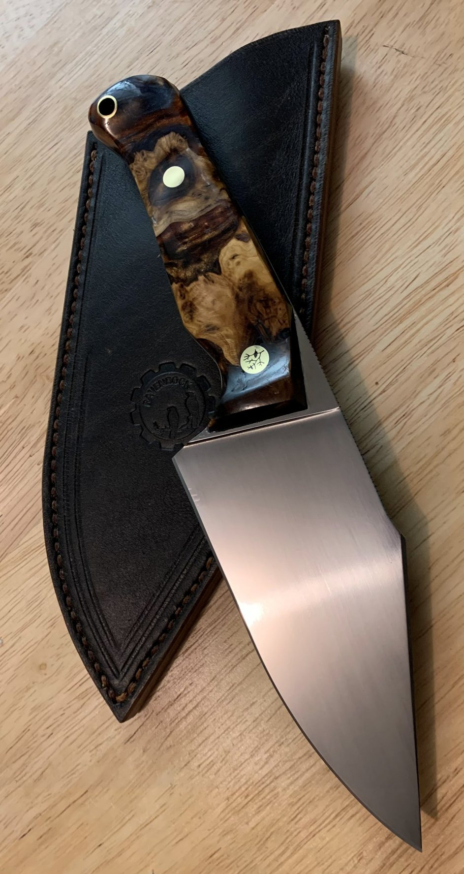 RRK-01-011 in full, a mirror-polished blade with deep amber burl handle, on its dark leather sheath