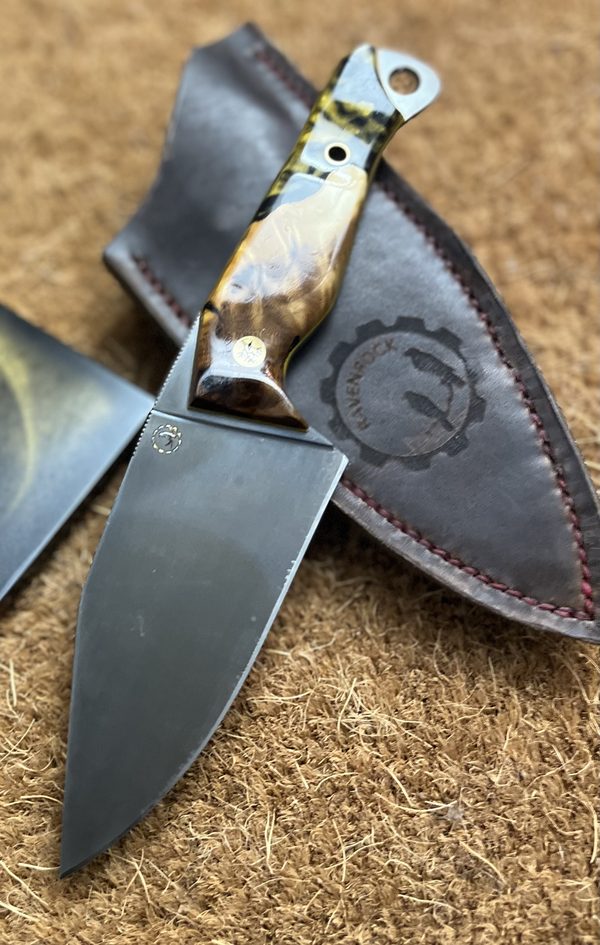 RRK-01-013, drop-point blade with deep grey forced patina and olive burl handle running into black and yellow marbled resin, on a Ravenrock-stamped leather sheath